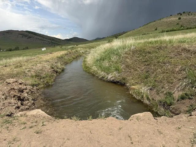 Natural water feature traversing a landscape of grassy hills