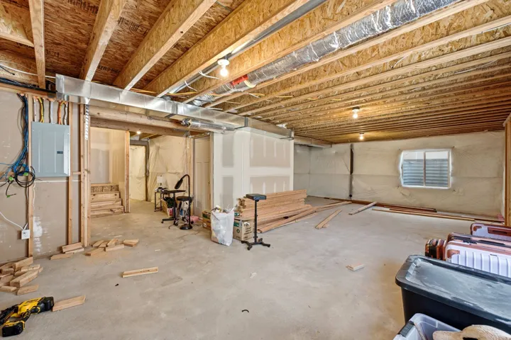 Spacious unfinished lower level featuring exposed wood joists and concrete flooring