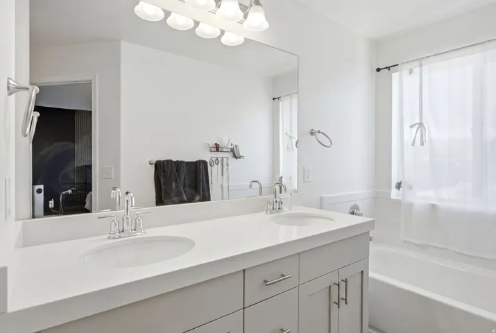 Double vanity with integrated sinks and chrome fixtures, set against a full-width mirror
