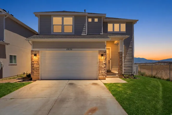 Modern two-story residence with a two-car garage, stone accents, and a concrete driveway