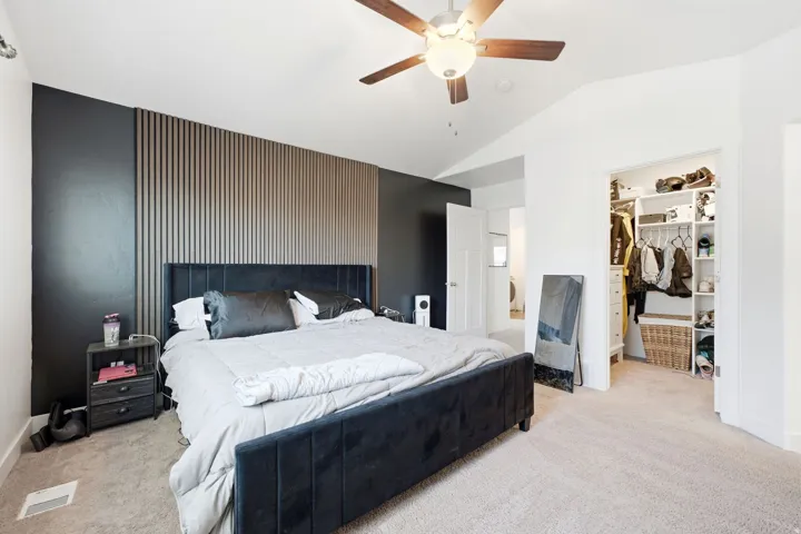 Spacious room featuring a vaulted ceiling and a wood-finish ceiling fan