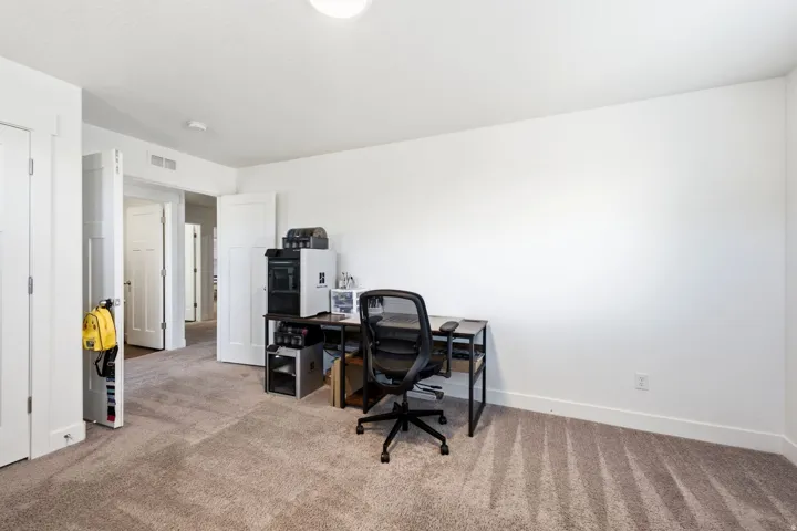 French doors leading to carpeted room with white walls, baseboards, and ceiling