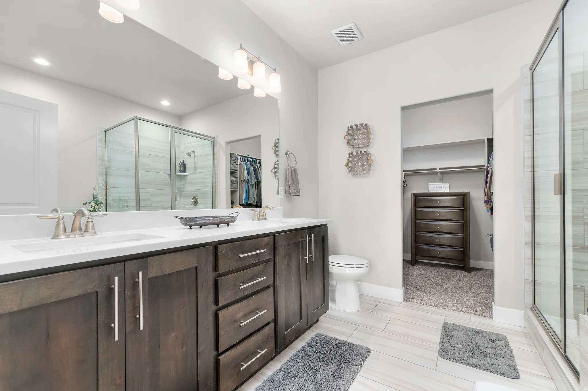 Double vanity with dark wood-finish cabinetry and brushed nickel hardware