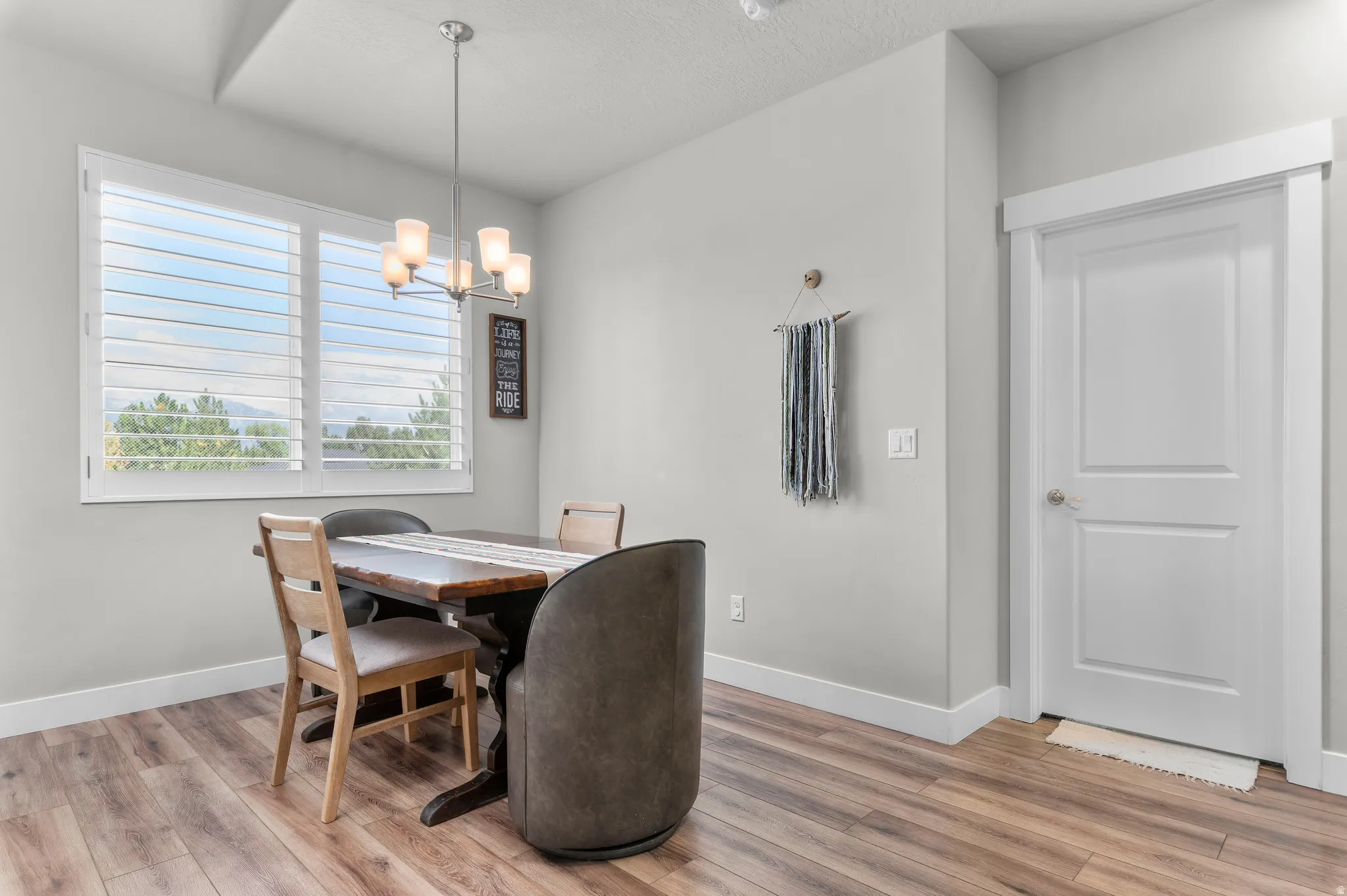 Spacious room featuring wood-finish flooring, white baseboards, and light gray walls