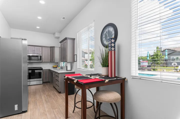 Kitchen featuring wood-finish flooring, recessed lighting, and stainless steel appliances including a refrigerator, range, and microwave