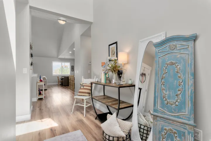 Light wood-finish flooring extending through an arched entryway