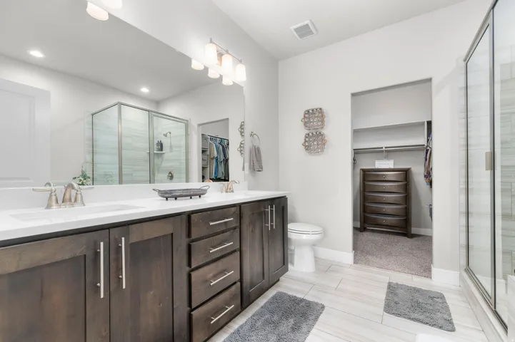 Double vanity with dark wood-finish cabinetry and brushed nickel hardware