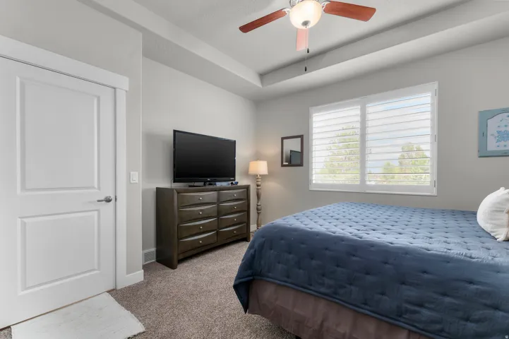 Bedroom featuring a tray ceiling, recessed lighting, and a ceiling fan with integrated lighting