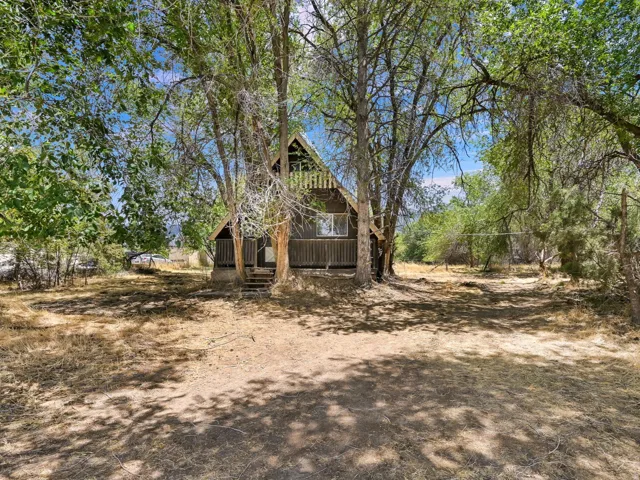 A-frame house with wood siding, framed by mature trees