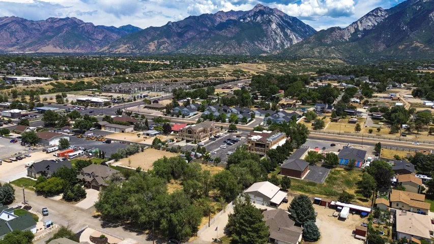 Expansive aerial perspective showcasing a residential and commercial area with mountainous terrain