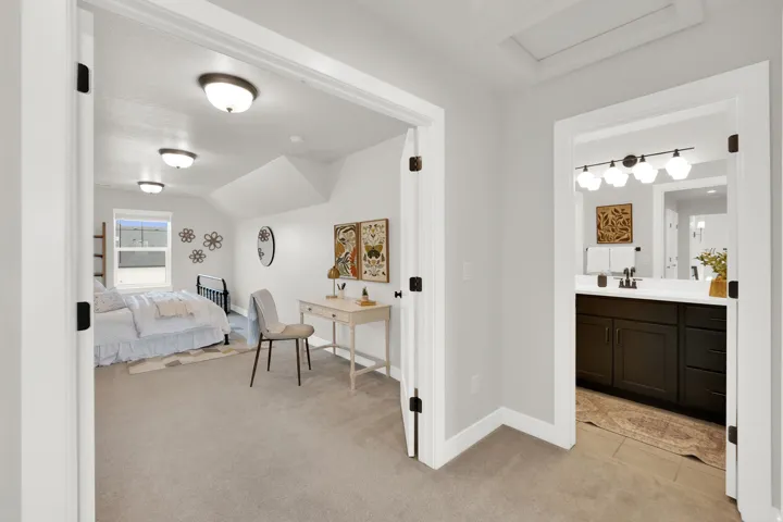 Light-filled bedroom with sloped ceilings, recessed window, and wall-to-wall carpeting