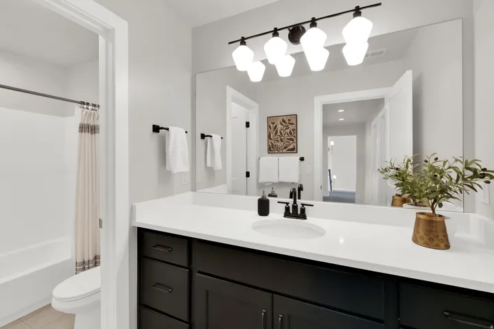Bathroom featuring a dark wood-finish vanity with a white countertop and an integrated sink