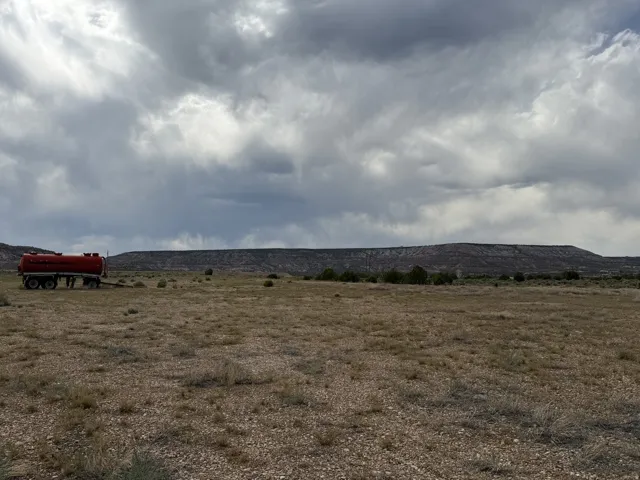 Expansive open land featuring natural desert vegetation and distant mountain ranges