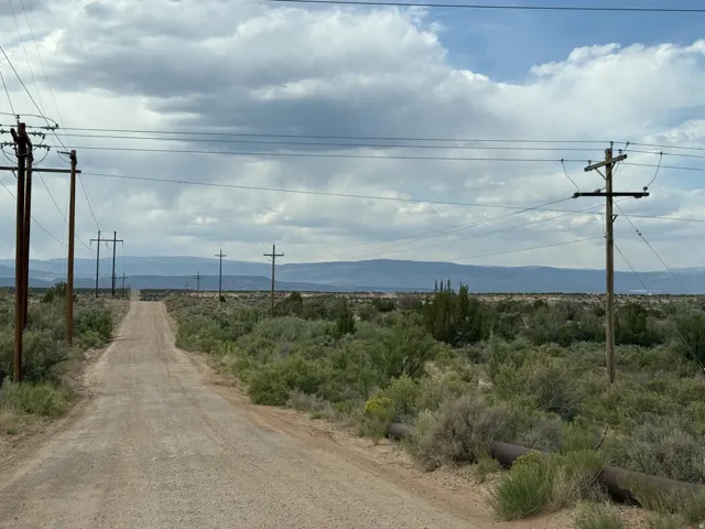 Expansive undeveloped land with a visible dirt road and scattered desert vegetation