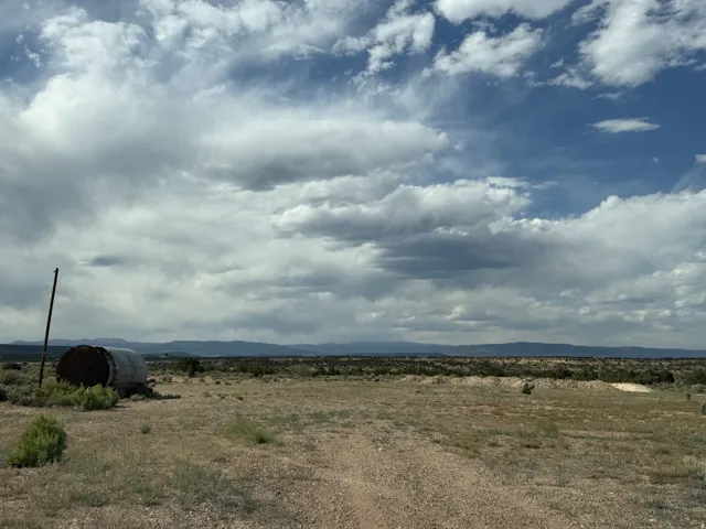 Expansive undeveloped land featuring a gravel path and distant mountainous terrain