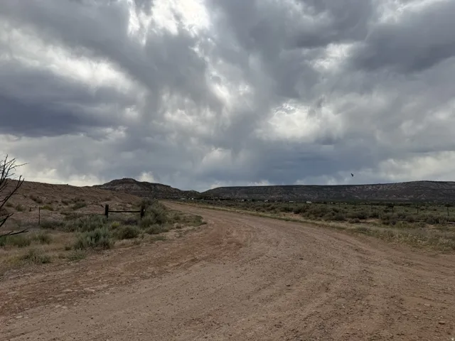 Expansive undeveloped land featuring a dirt road and distant hills
