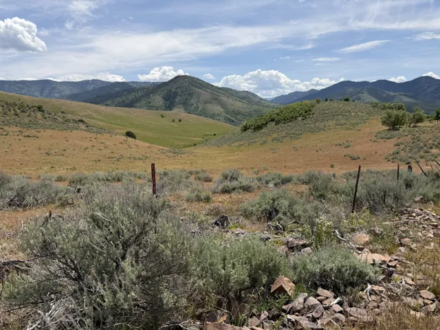 Expansive, open land featuring rolling hills and distant mountains