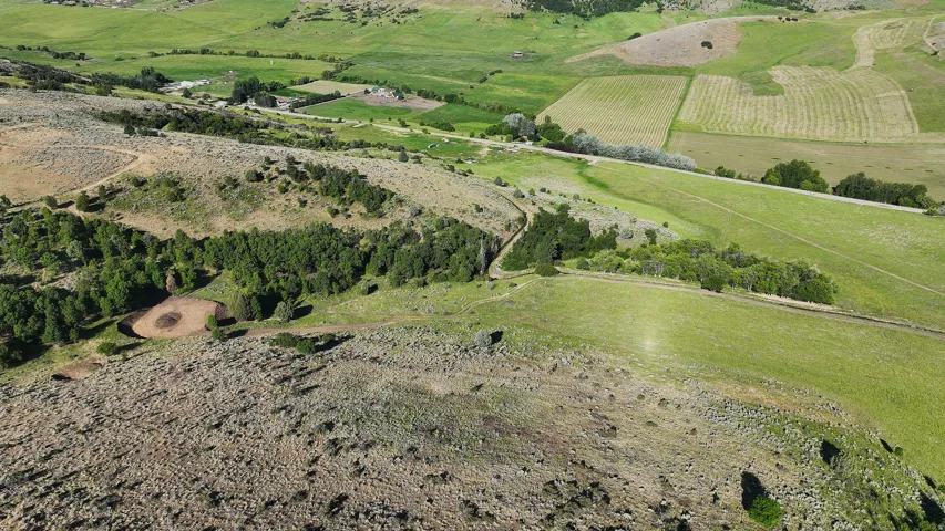Expansive rural landscape featuring varied topography, encompassing both lush green fields and arid, rocky terrain