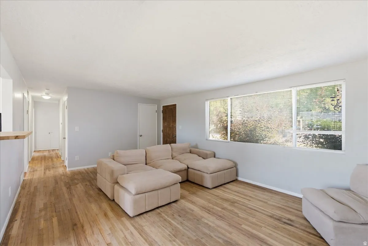 Spacious living area featuring wood-finish flooring, light gray walls, and white trim