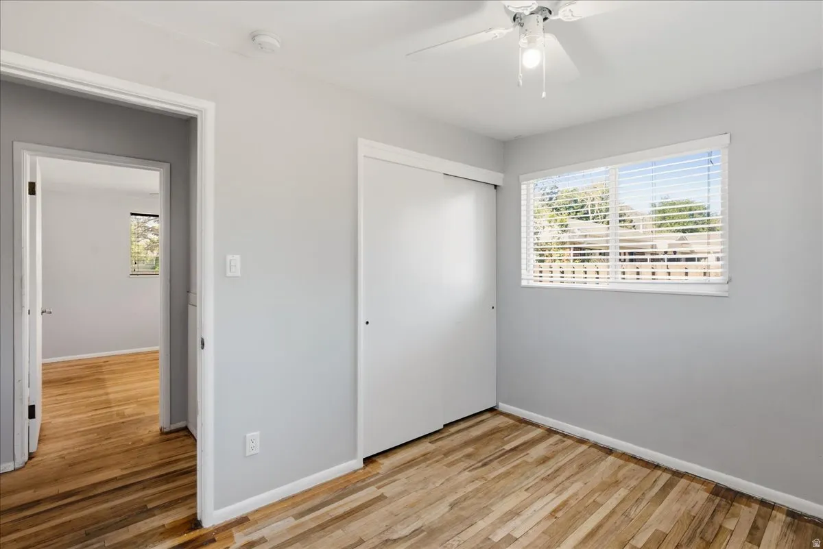 Interior room featuring wood-finish flooring, light gray walls, and white trim