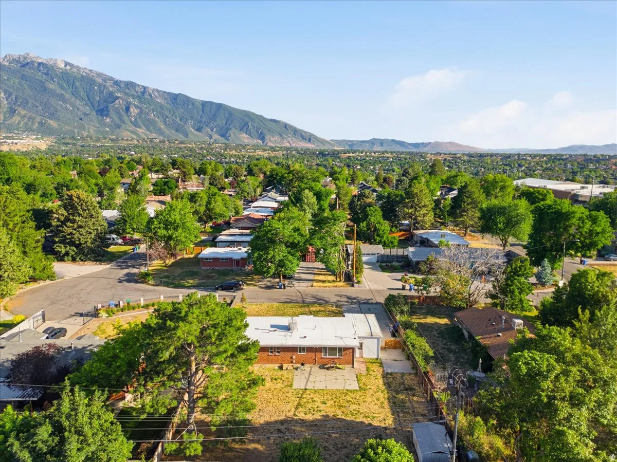 Expansive neighborhood setting featuring mature trees and mountain scenery