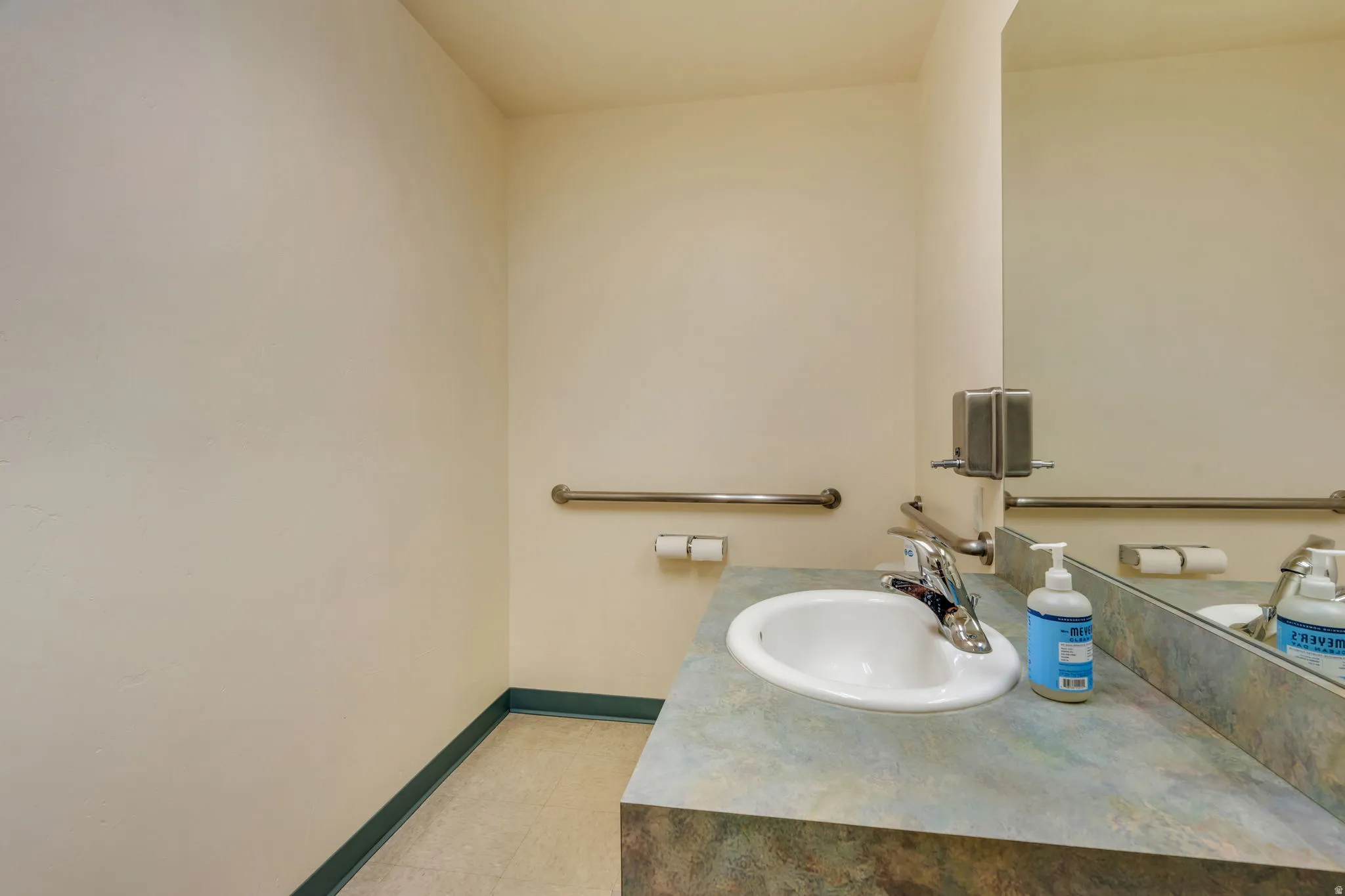 Bathroom vanity with integrated sink, stone-look countertop, and a large wall-mounted mirror