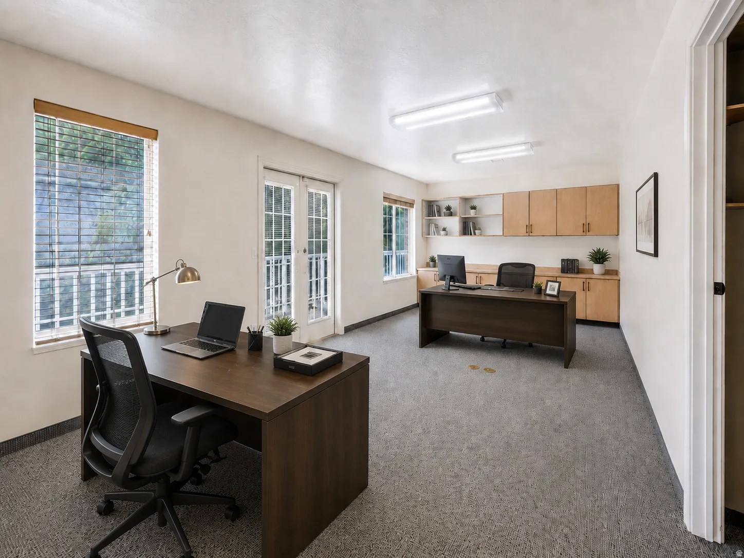 Office space featuring light-colored walls and grey textured flooring