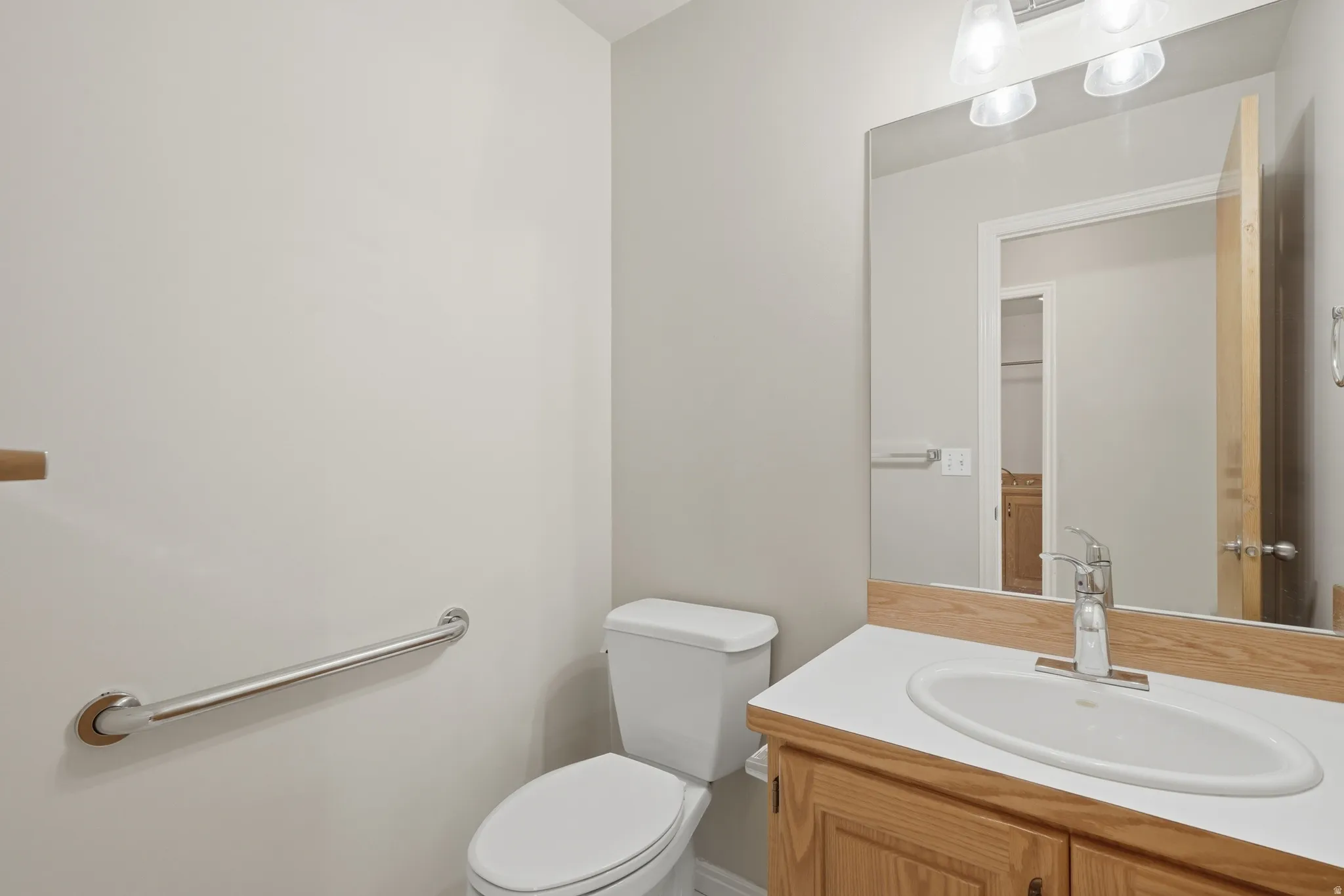 Bathroom featuring a wood-finish vanity with a white countertop and an undermount sink