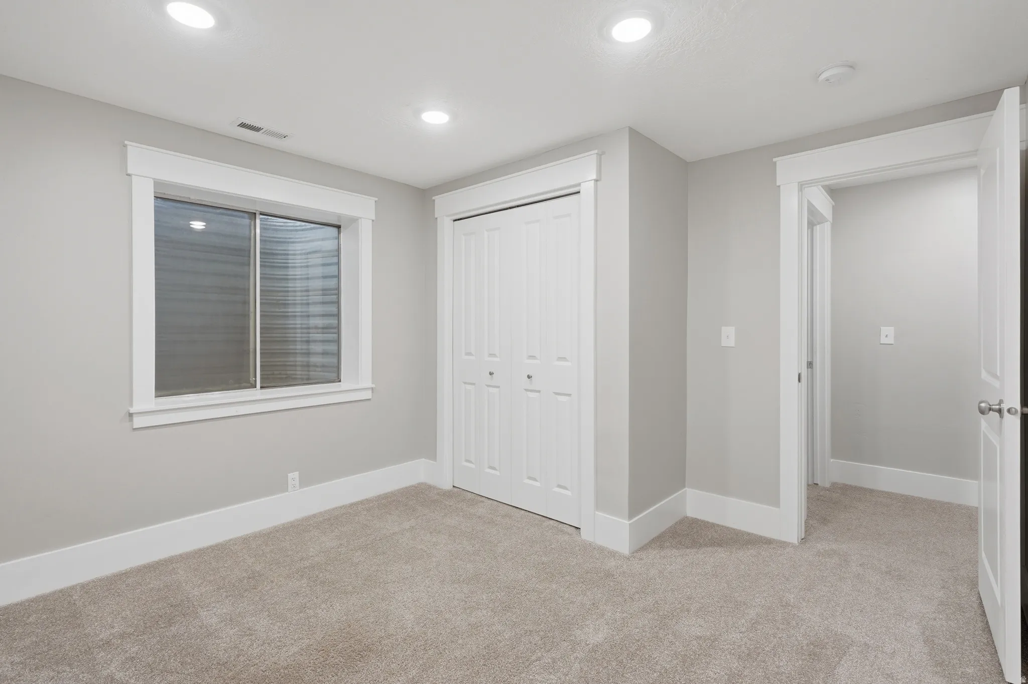 Neutral-toned carpet flooring and light gray wall paint establish a clean aesthetic