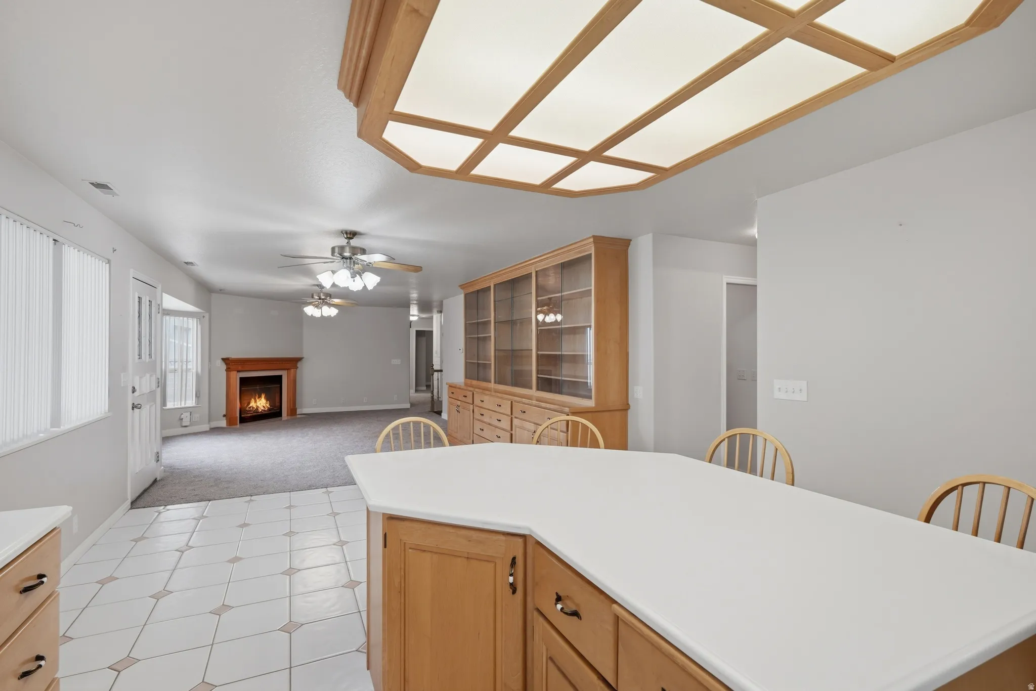 Kitchen island with light wood cabinetry and a white countertop