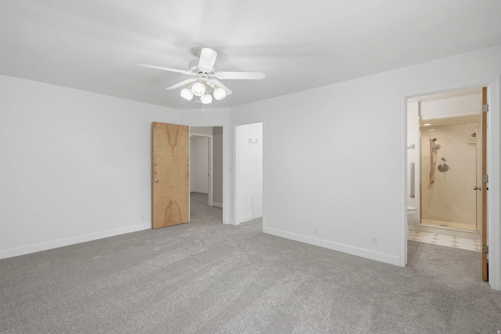 Spacious room featuring light gray carpeting and walk in closet