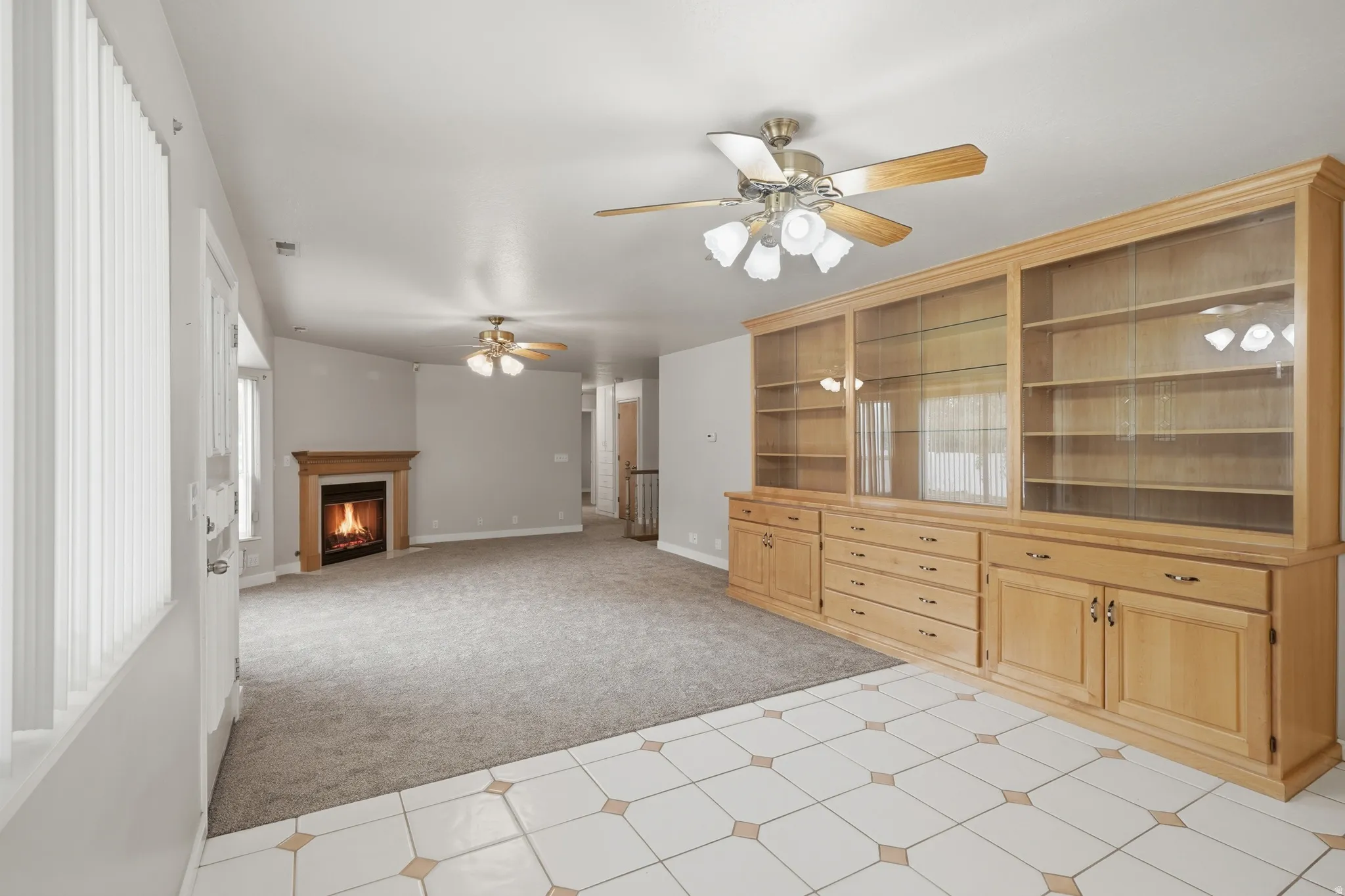 Living area featuring an extensive built-in display unit with glass-front cabinetry and drawer storage