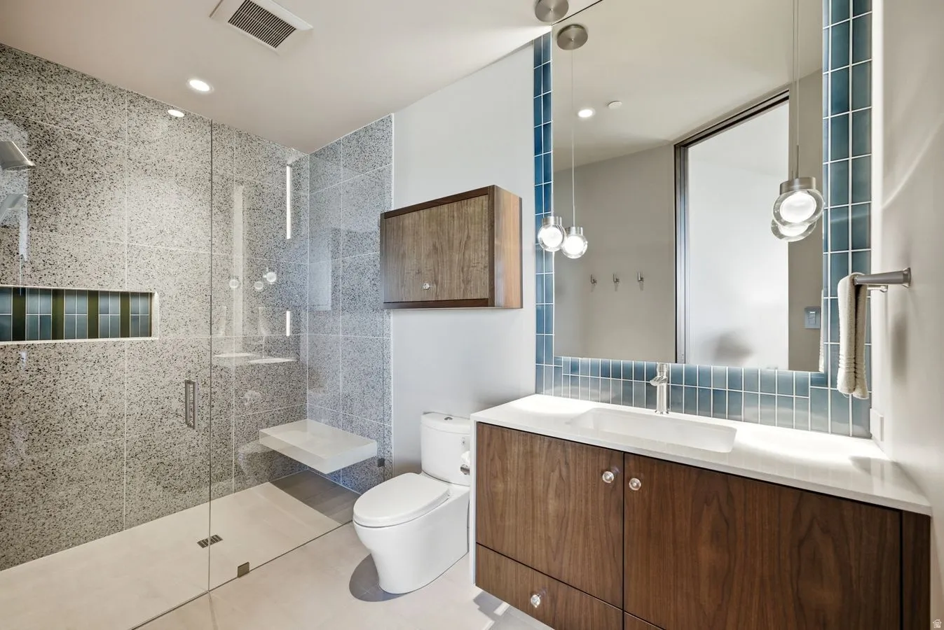 Glass-enclosed shower with a built-in bench and recessed niche