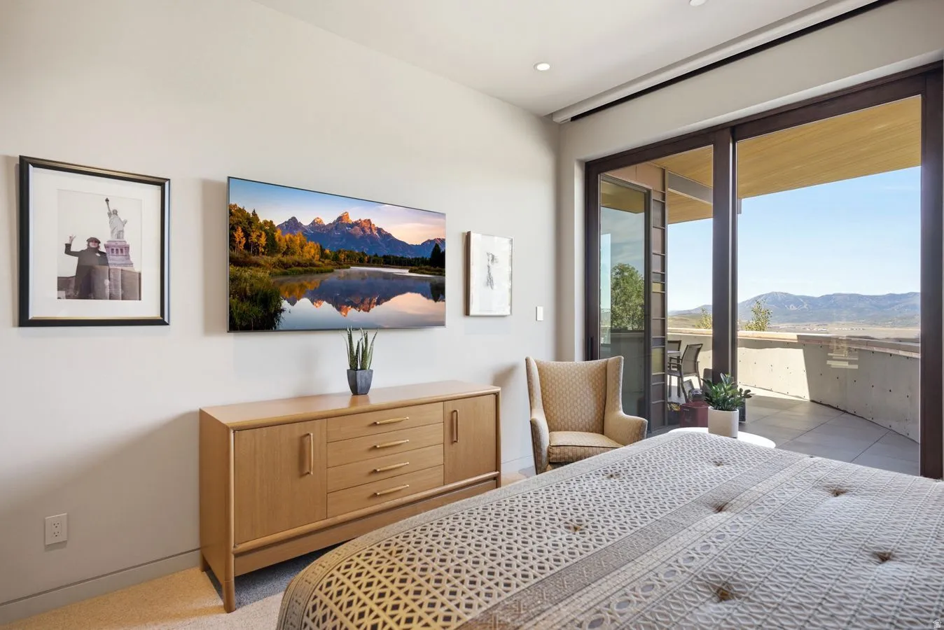Sliding glass doors opening to an exterior balcony, recessed ceiling lighting, and a neutral wall color