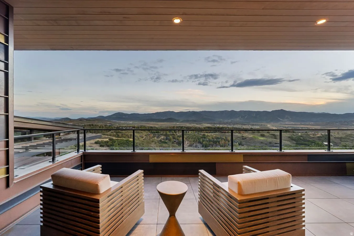 Expansive balcony featuring a glass panel railing, recessed lighting, and a wood-finish ceiling