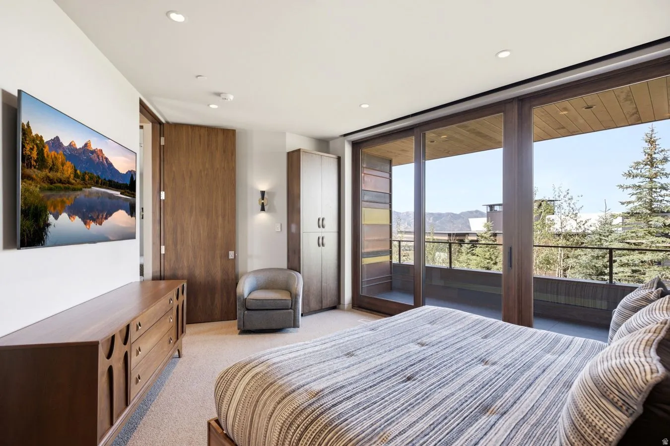 Wood-finish sliding glass doors open to an exterior balcony