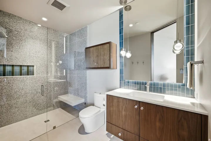 Glass-enclosed shower with a built-in bench and recessed niche