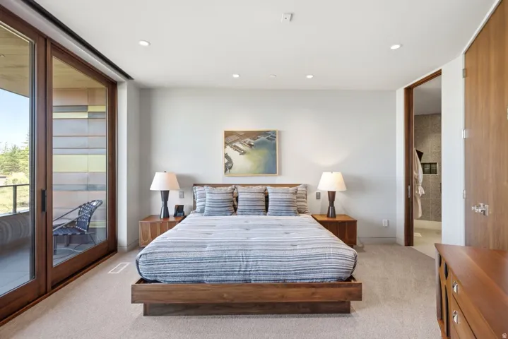 Expansive sliding glass doors, recessed lighting, wood-finish flooring, wood-finish doors, and a neutral wall color