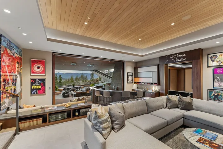 Integrated bar area, built-in window seating, recessed lighting, wood-paneled ceiling, and large sliding glass doors