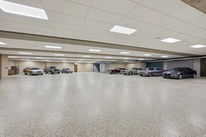 Expansive garage with durable speckled flooring, recessed overhead lighting, and a suspended acoustic tile ceiling