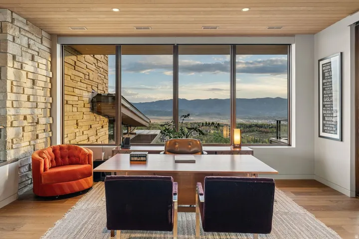 Floor-to-ceiling windows, wood-finish ceiling, stone accent wall, recessed lighting, and wood-finish flooring