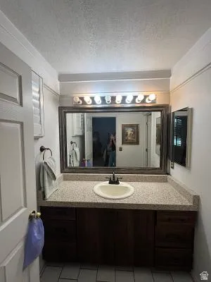 Bathroom vanity featuring a speckled countertop, integrated sink, and dark wood-finish cabinetry