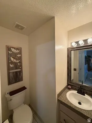 Vanity featuring an integrated sink, speckled countertop, and dark-finish faucet