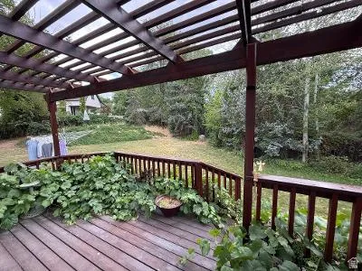 Expansive wood deck featuring a slatted pergola overhead
