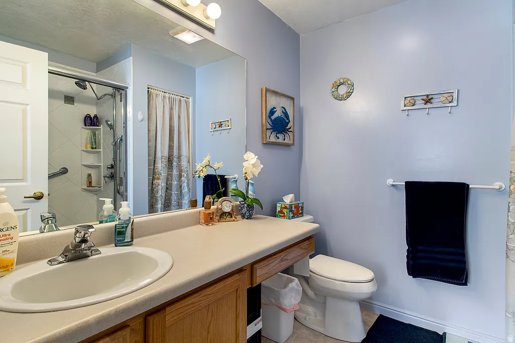 Bathroom featuring a vanity with an integrated sink, a large wall-mounted mirror, and a three-light fixture
