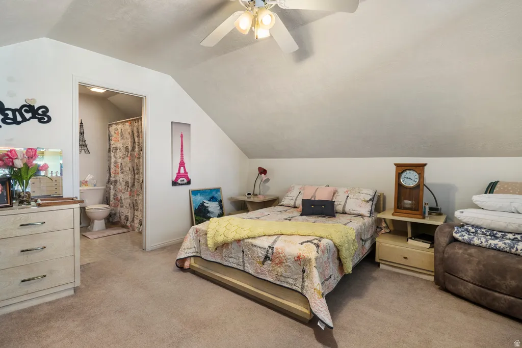 Carpeted room with sloped ceilings and an attached bath