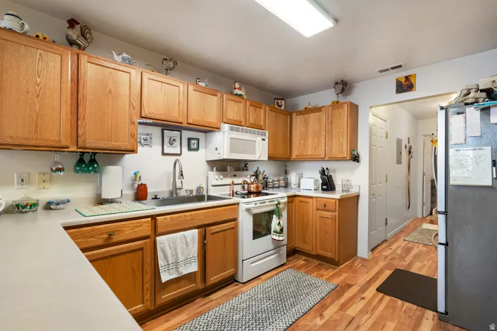 Kitchen featuring wood-finish cabinetry, white countertops, and wood-finish flooring