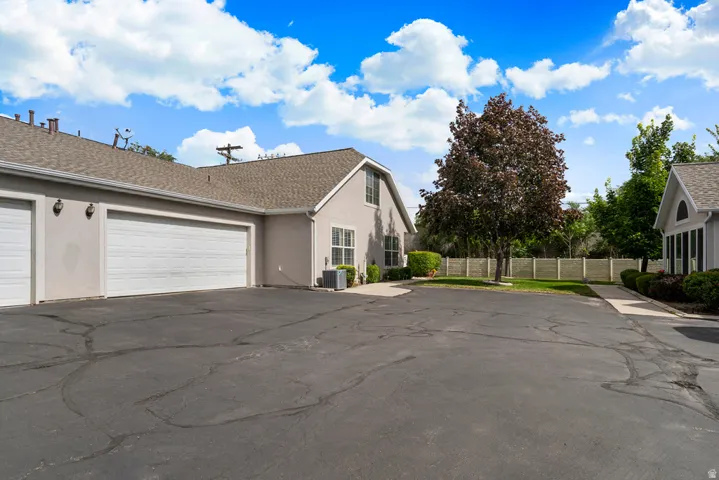 Expansive asphalt driveway with multiple garage doors