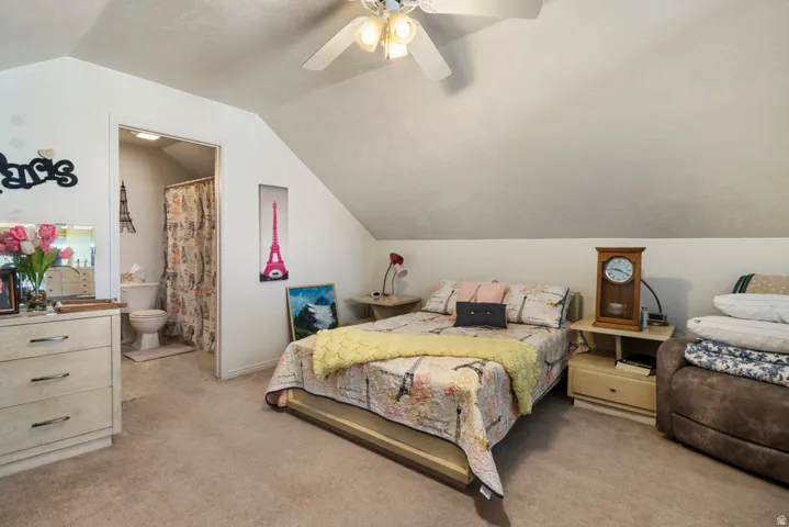 Carpeted room with sloped ceilings and an attached bath