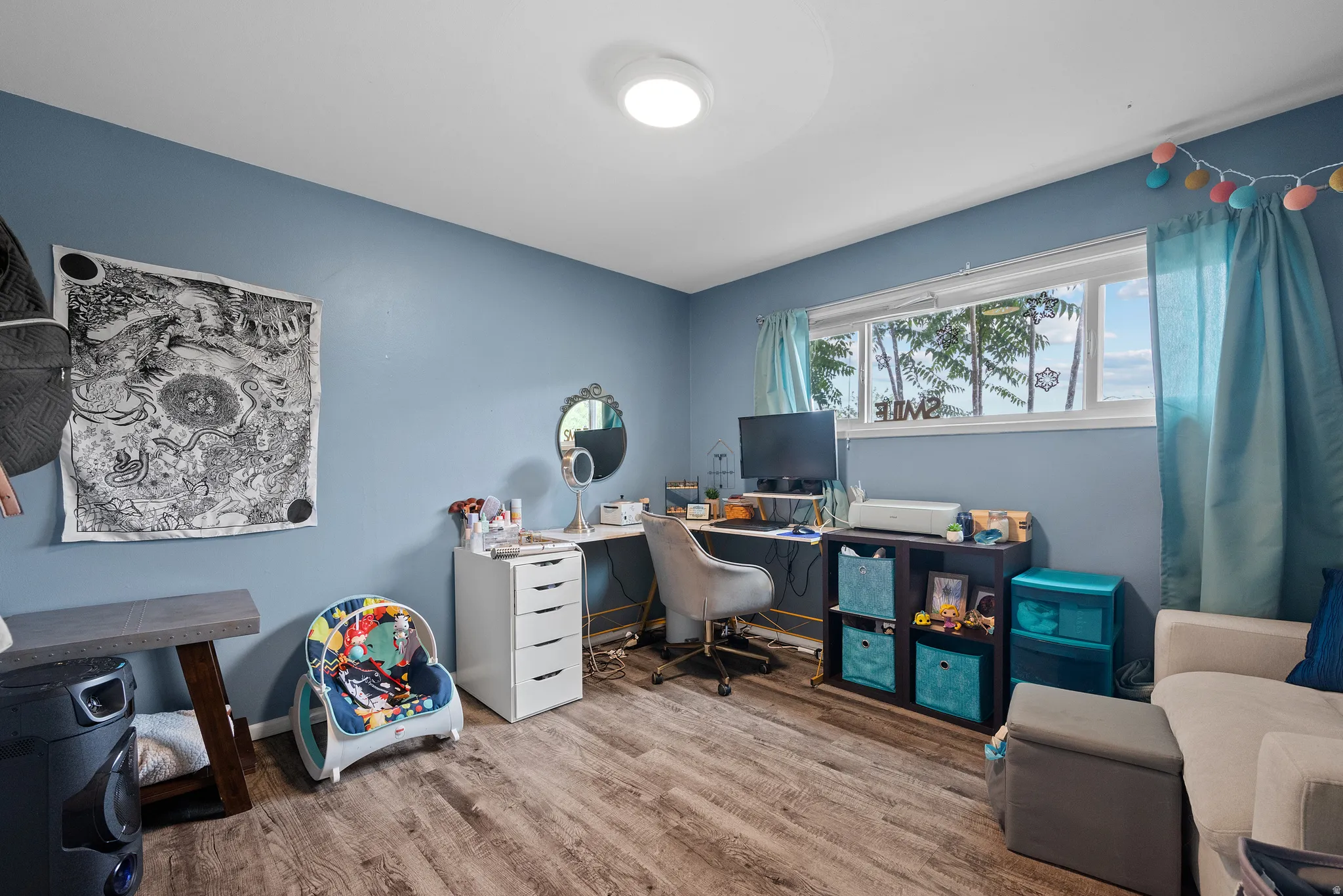 Room featuring wood-finish flooring, a contemporary ceiling light fixture, and a large window with white trim